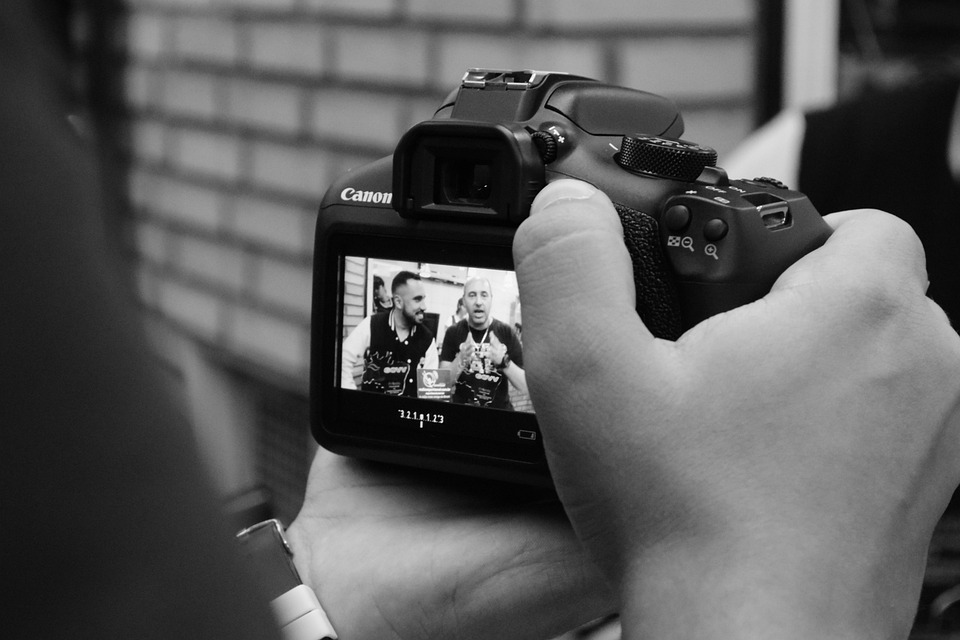 men recording something with canon camera