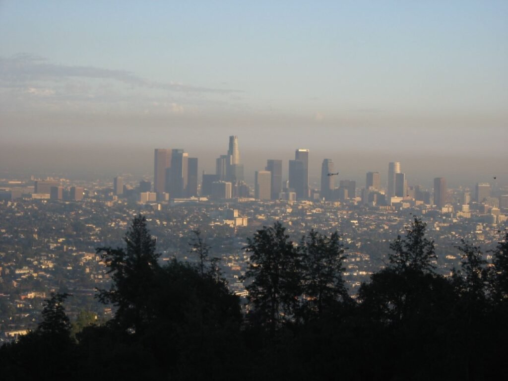 A helicopter flying above the Los Angeles skyline near Griffith Observatory